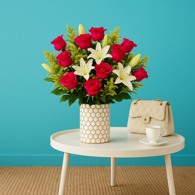 Hexara Column vase from floralsuppliespoint1.com with vibrant red roses, white lilies, and yellow fillers, styled on a chic table with purse and coffee cup.