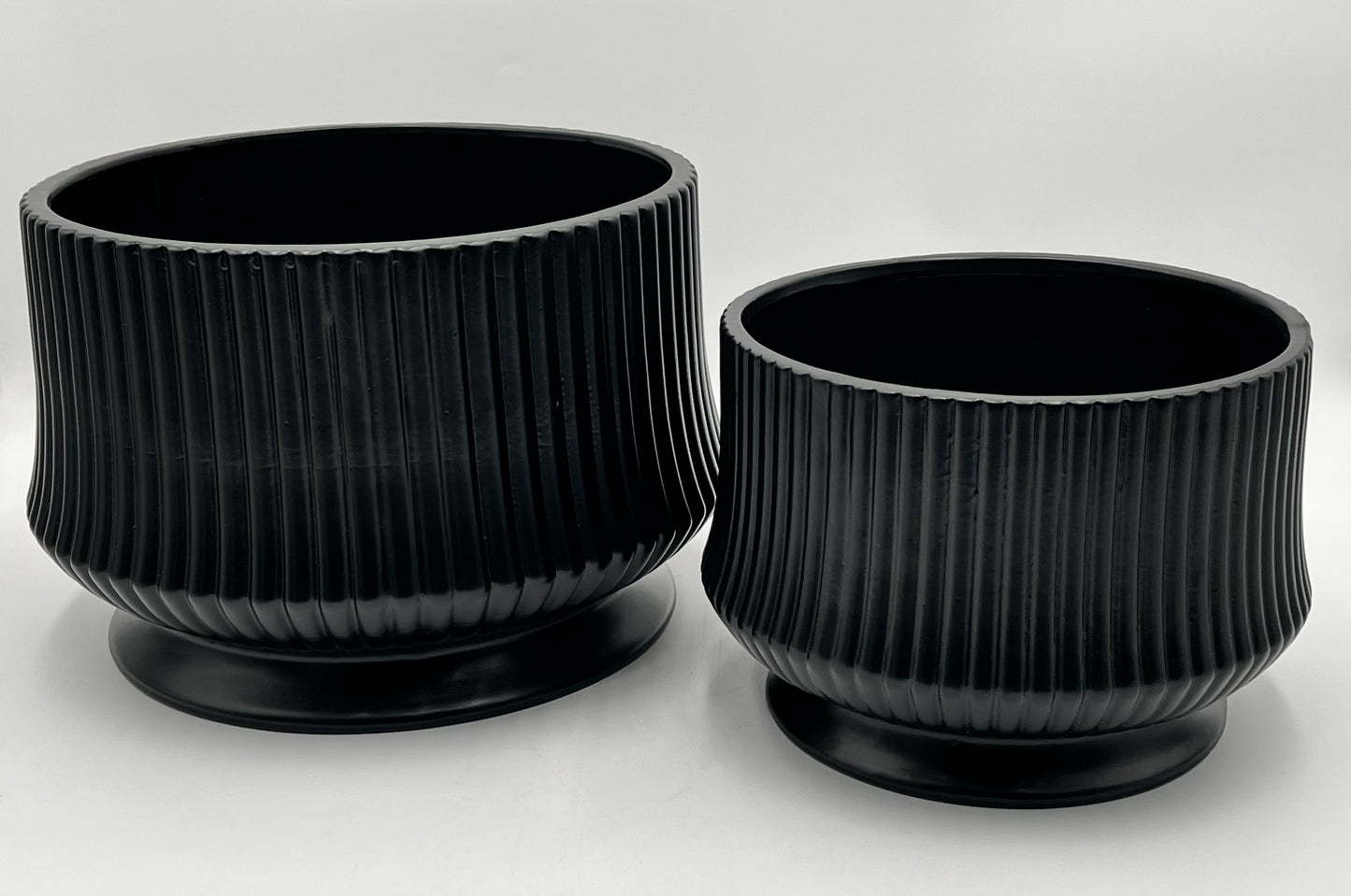 Cove Ridge Set ceramic vases in black with ribbed design and pedestal base, sizes 8"x10.5 Op and 6.5"x8 Op, total weight 11.50 lbs, available at floralsuppliespoint1.com.