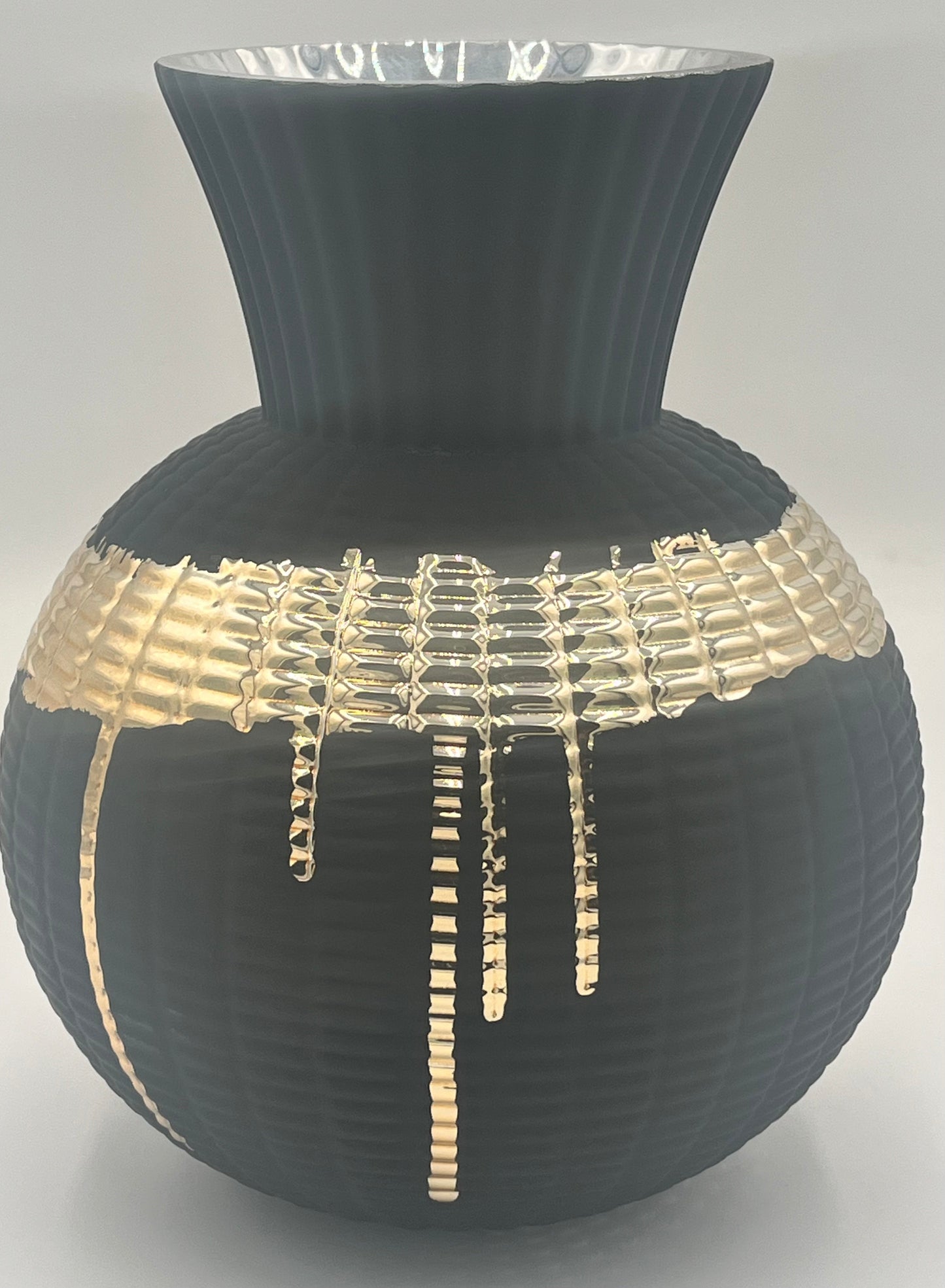 The Obsidian Pour 9.5x4 Op vase by Floral Supplies Point features matte black ribbed texture, a wide flared rim, and a molten gold glaze dripped in an irregular grid across the middle for striking contrast.