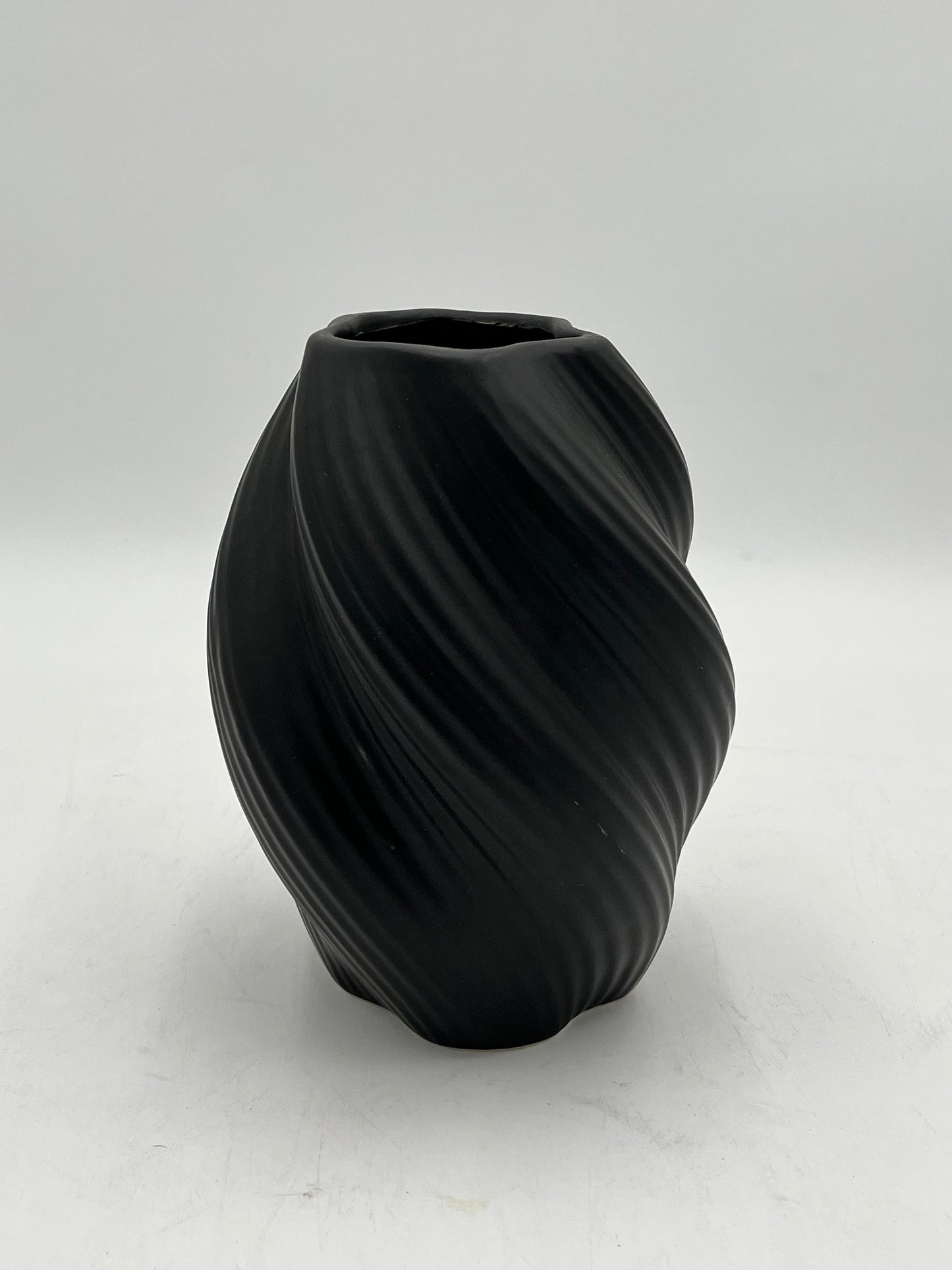 Decorative ceramic vase with a modern spiral design, perfect for elegant and minimalist interiors. Sold by floralsuppliespoint1.com for $10.99 in black