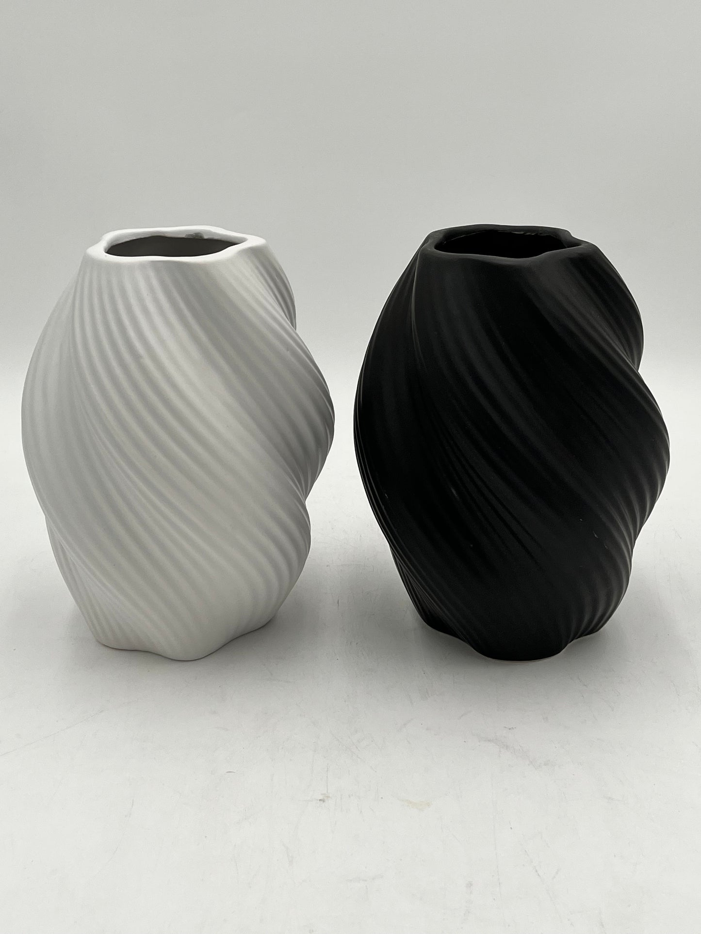 Decorative ceramic vase with a modern spiral design, perfect for elegant and minimalist interiors. Sold by floralsuppliespoint1.com for $10.99 in black or white