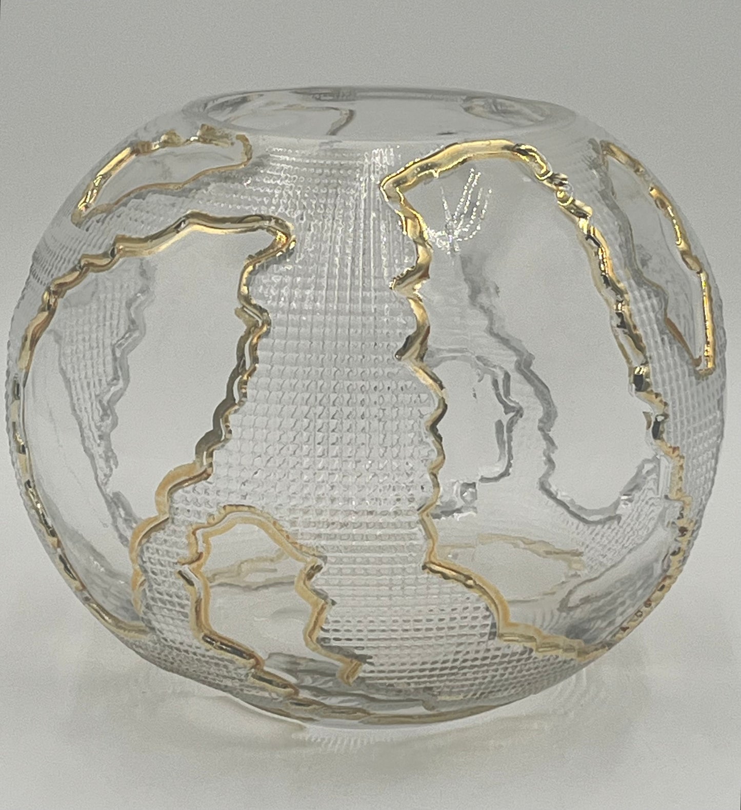 The Lumen Globe 6.5x3.5 Op by Floral supplies Point is a round, clear glass vase with a textured surface and gold-outlined continents, creating a sculptural globe effect that highlights landmasses against the transparent background.