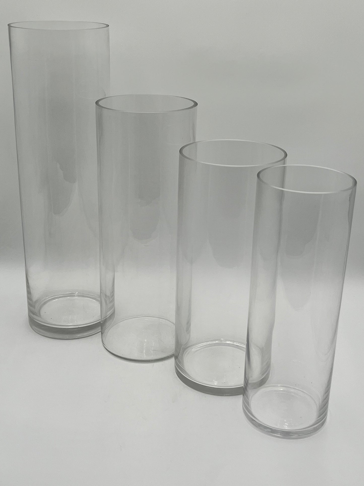 The LuxeGlass Cylinder Collection are clear glass cylinder vases in four sizes, ideal for floral designs, candles, or events. Sturdy, elegant, and sold individually by floralsuppliespoint1.com.