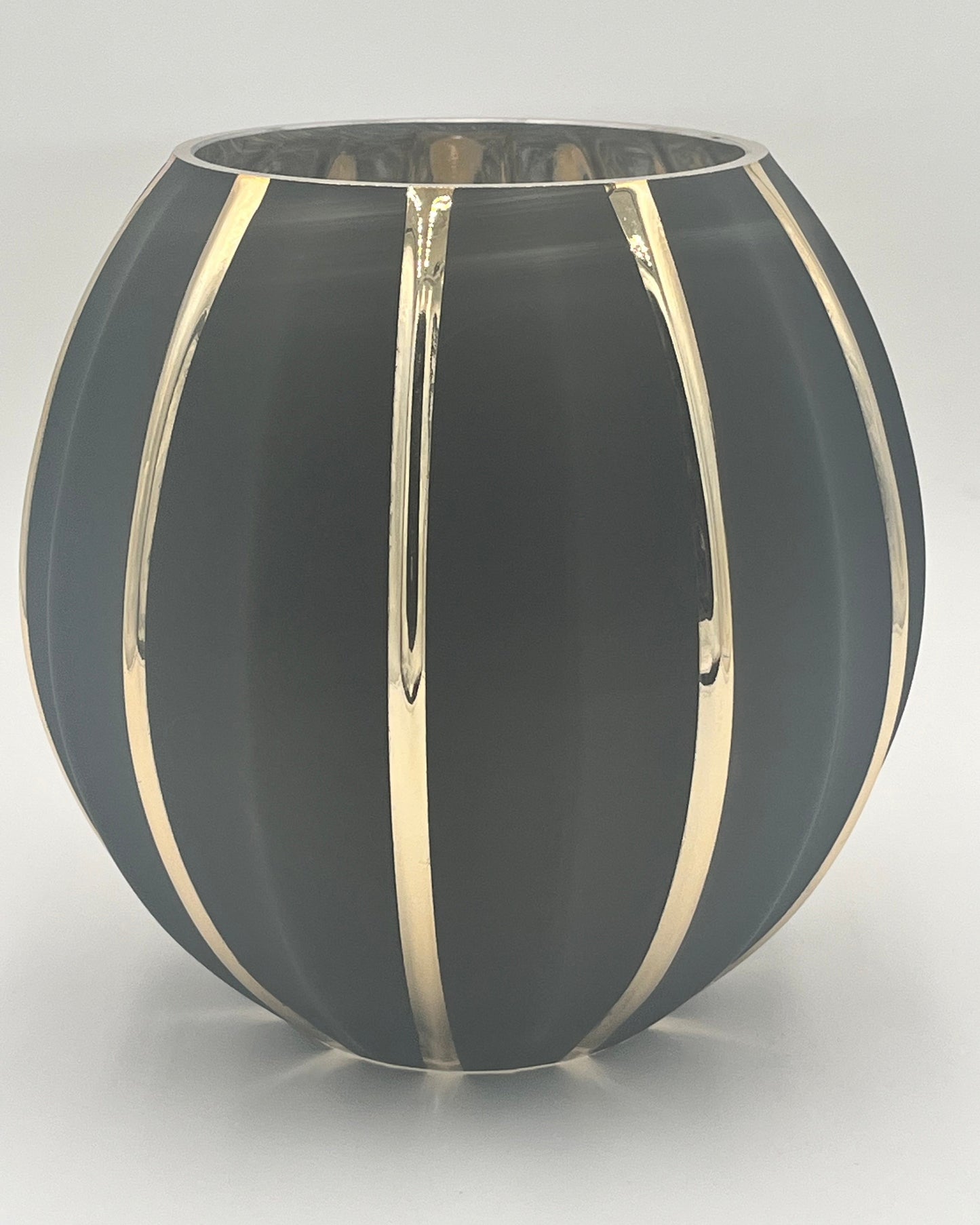 The Noctara Globe 8x4.75 Op by Floral supplies Point is a round vase in matte black with glossy vertical gold stripes, creating a striking sculptural look against its smooth surface and a plain white background.