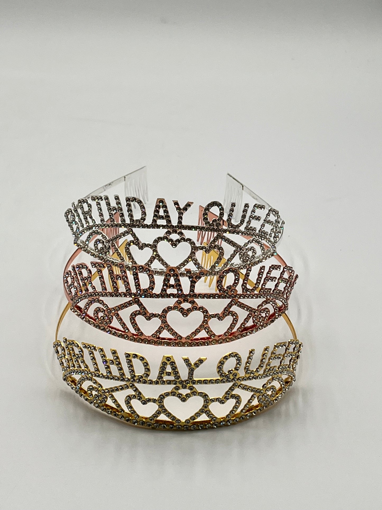 Three rhinestone “Birthday Queen” tiaras in gold, rose gold & silver with heart accents, sold retail & wholesale by floralsuppliespoint1.com.