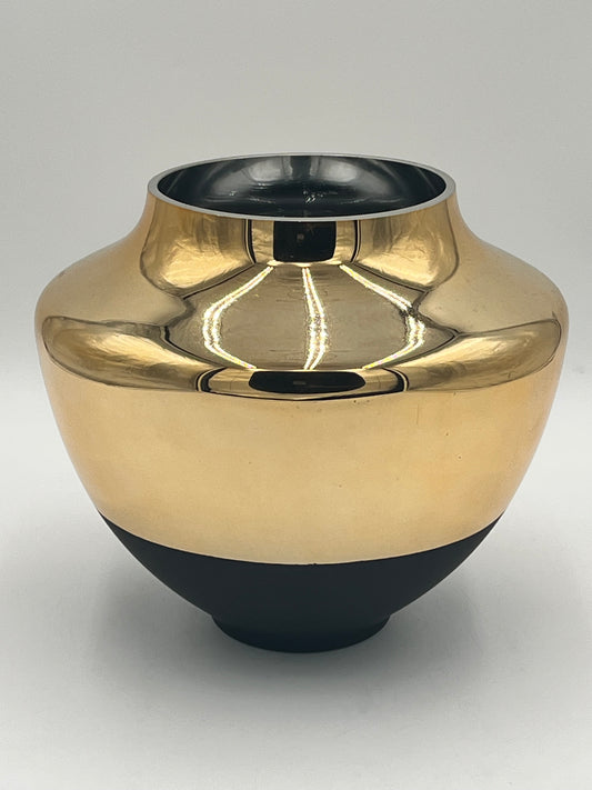 The Altura 9 x 5 Op vase by Floral Supplies Point features a shiny gold and black ceramic design with a wide body, narrow neck, and round opening, reflecting light against a plain white background for an elegant, architectural look.