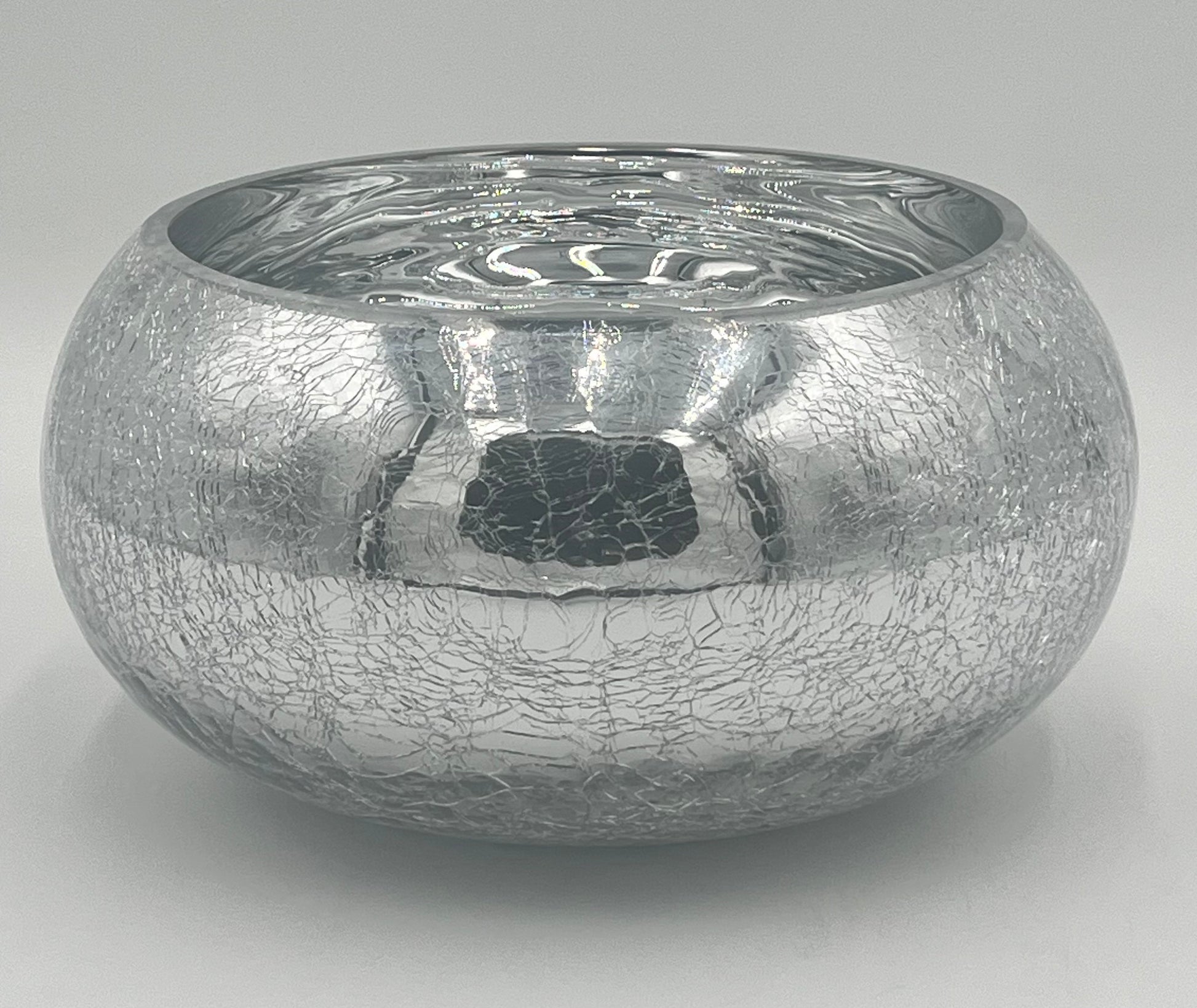 The Floral Supplies Point Crystallo Basin 5.25 x 7.25 Op is a round, silver bowl with a wide opening, featuring a reflective crackled exterior and smooth shiny interior, shown against a plain light gray background.