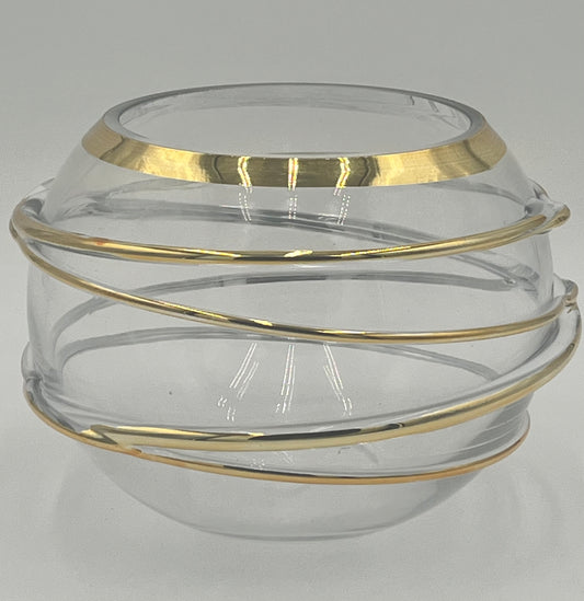 The Helixa Sphere 5.5x4.5 Op by Floral supplies Point is a round, clear glass vase with a wide opening and gold spiral metallic bands, embodying contemporary luxury against a plain light gray background.