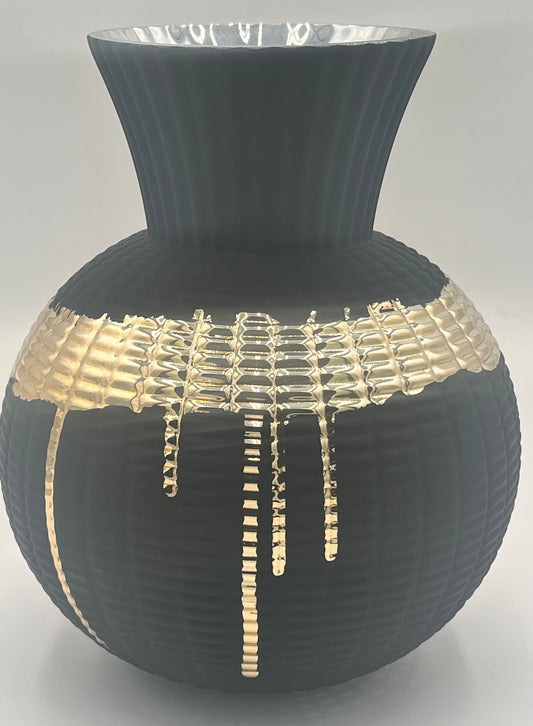 The Obsidian Pour 9.5x4 Op vase by Floral Supplies Point features matte black ribbed texture, a wide flared rim, and a molten gold glaze dripped in an irregular grid across the middle for striking contrast.
