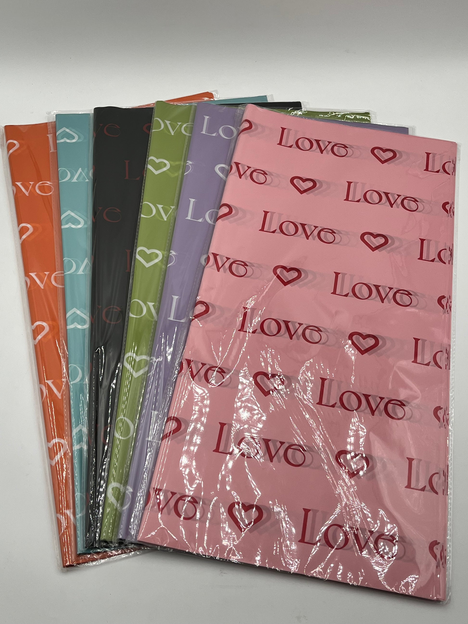 LOVE Wraps Edition in Orange, Light Blue, Black, Light Green, Lavender & Pink, 22x22 inch sheets with heart and “LOVE” design. Sold @ floralsuppliespoint1.com for $9.99