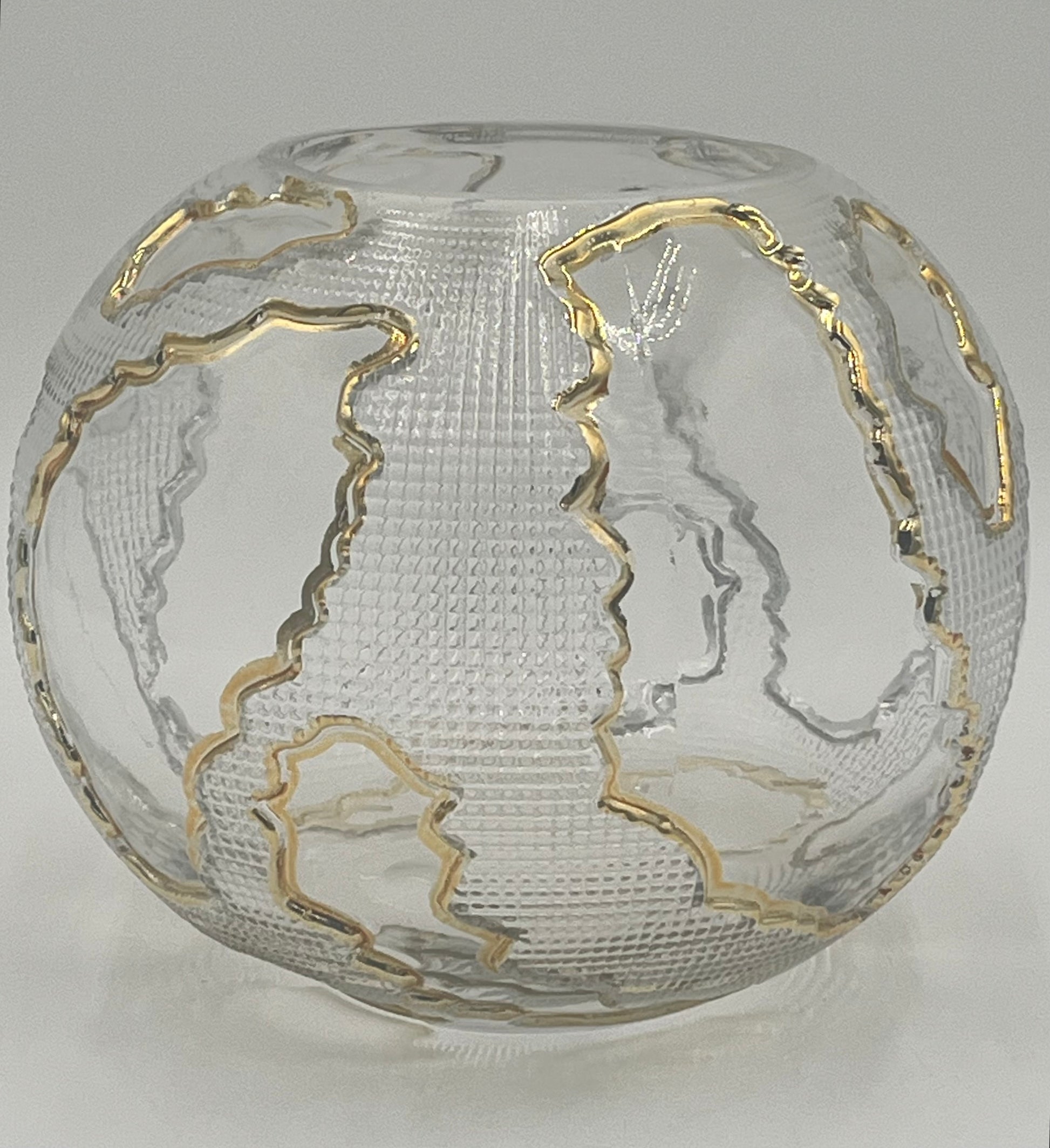 The Lumen Globe 6.5x3.5 Op by Floral supplies Point is a round, clear glass vase with a textured surface and gold-outlined continents, creating a sculptural globe effect that highlights landmasses against the transparent background.