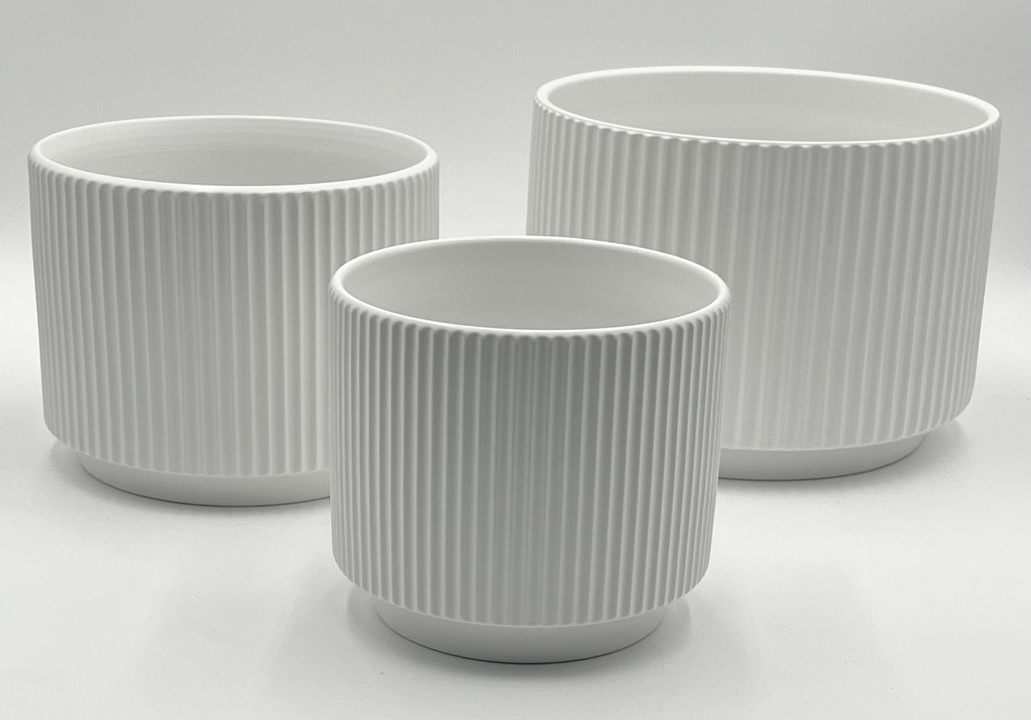 Ridge Nest Set of 3 ribbed ceramic vases in white with sizes 5.75x5.75", 6.25x7", and 7.25x9" (height x opening), total 11.80 lbs, available in black or white at floralsuppliespoint1.com.