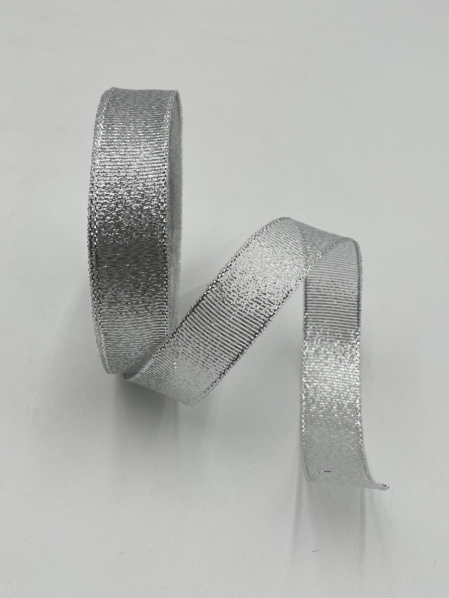 Silver polyester ribbon roll in 1” x 25 yards, ideal for floral design, gifts and crafts. Sold individually by floralsuppliespoint1.com.