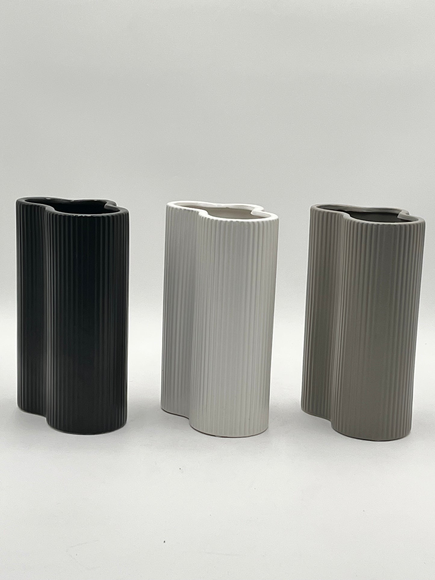 Waveline Core ceramic vases in Matte Black, White, and Grey with ribbed design, sold by floralsuppliespoint1.com. Each vase measures 9" x 5" and weighs 2.30 lbs, perfect for modern floral arrangements.